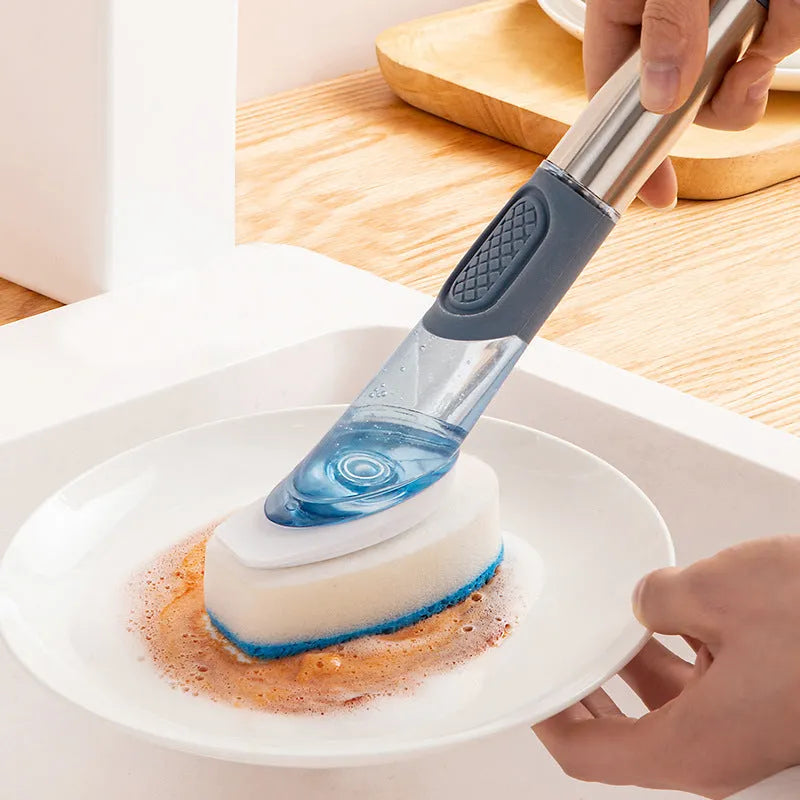 Long handled kitchen cleaning brush with a soap dispenser button and a stainless steel scouring block.