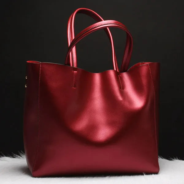 Women's cowhide shoulder bag in silver colour with adjustable straps, showing dimensions of 34cm length.