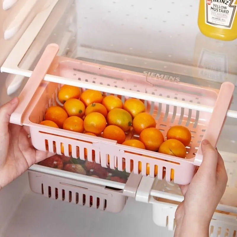 Blue telescopic refrigerator storage basket with adjustable width from 22cm to 34cm on a kitchen counter