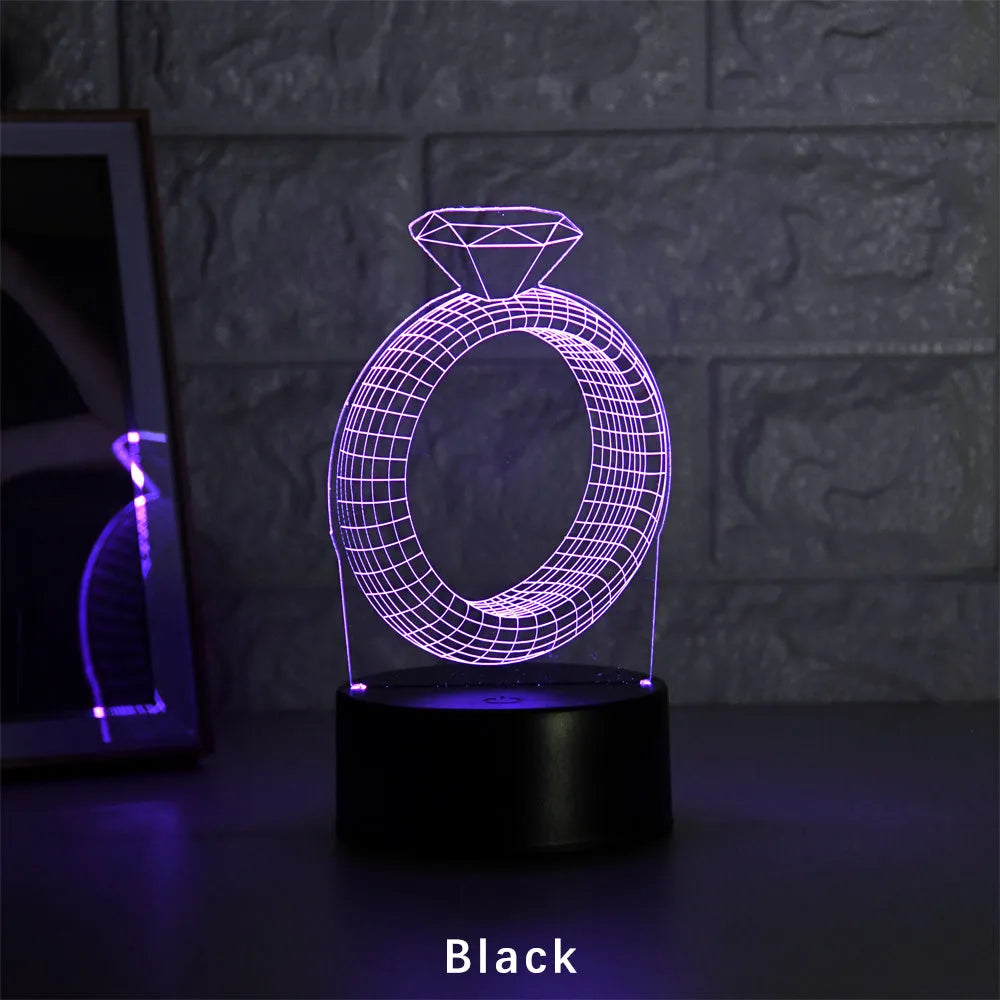 3D LED night light projecting diamond ring design with colour-changing illumination on bedside table