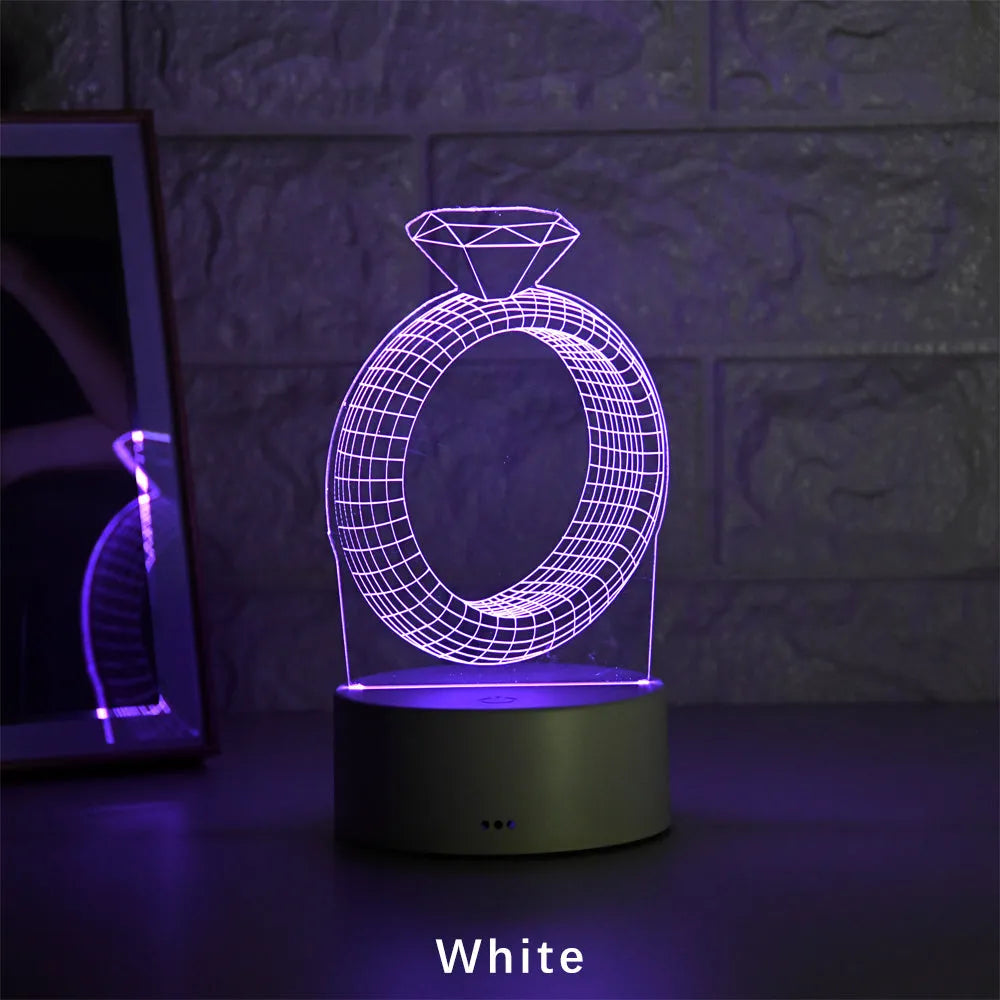 3D LED night light projecting diamond ring design with colour-changing illumination on bedside table