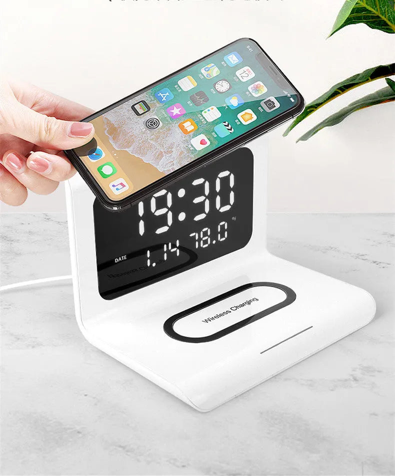 White wireless charger alarm clock showing time, date, temperature and humidity on display with smartphone charging wirelessly