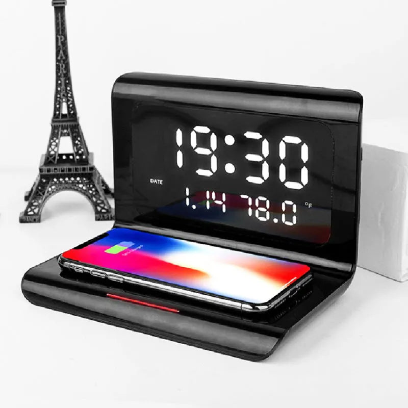 White wireless charger alarm clock showing time, date, temperature and humidity on display with smartphone charging wirelessly