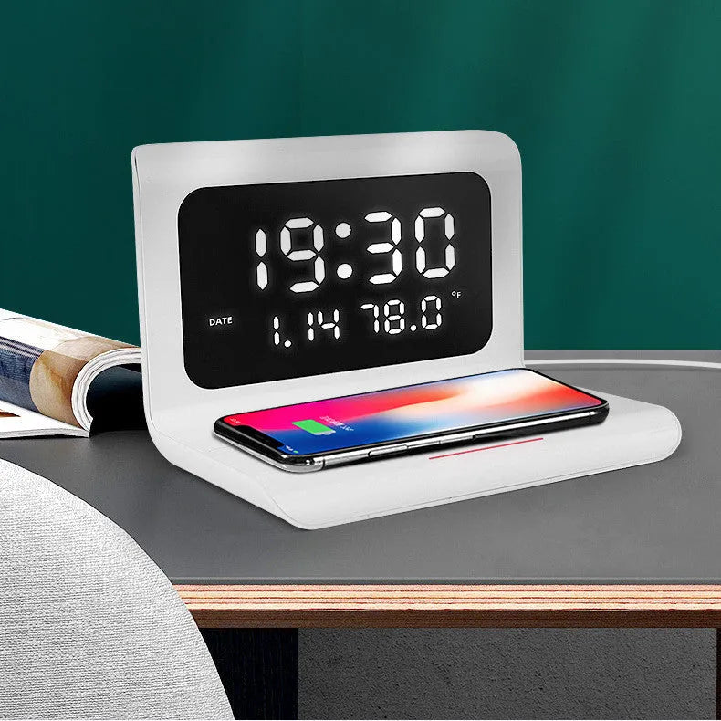 White wireless charger alarm clock showing time, date, temperature and humidity on display with smartphone charging wirelessly