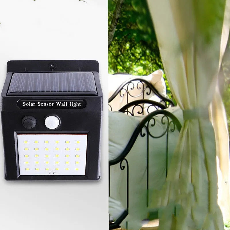 Solar-powered outdoor garden lamp with LED lights and a motion sensor on a stake.