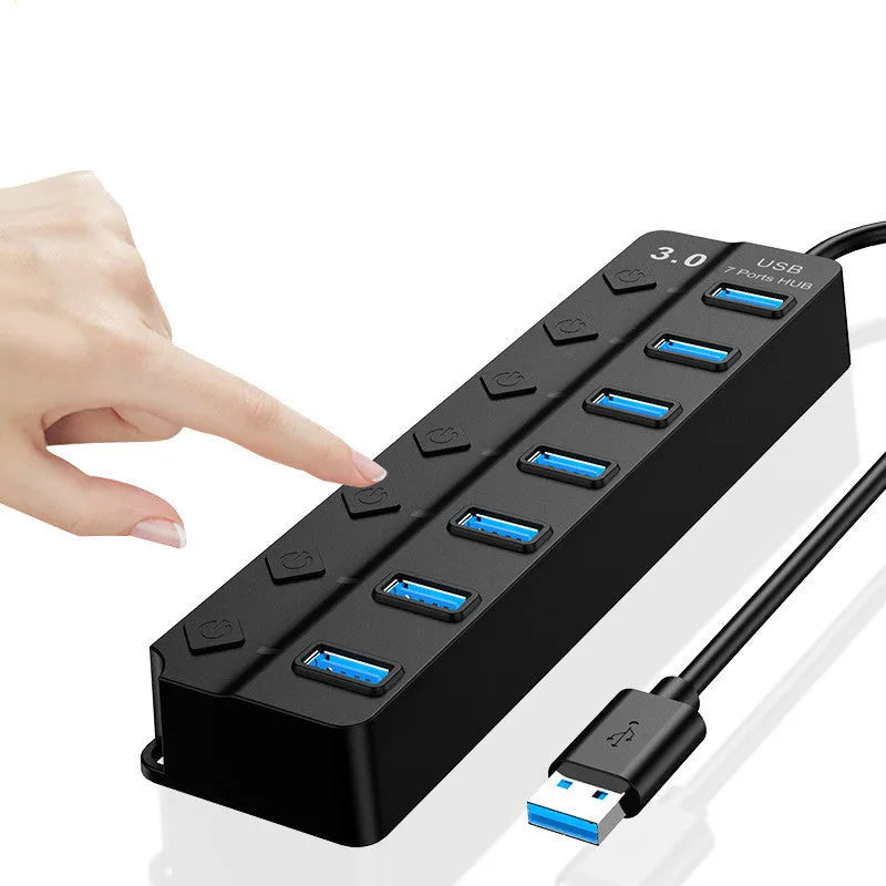 Black 7-port USB 3.0 hub with external power adapter on desk