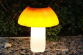 Solar-powered mushroom-shaped garden light with ground spike for lawn or border insertion.