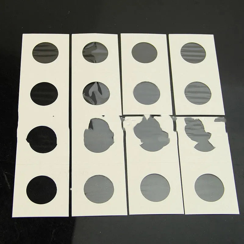 Set of 50 white paper coin protectors in a clear plastic OPP bag for commemorative coin collection.