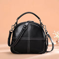 Round leather handbag with double soft handles showing zipper closure and compact 21cm width
