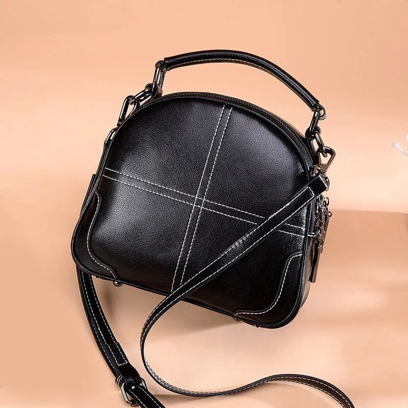 Round leather handbag with double soft handles showing zipper closure and compact 21cm width