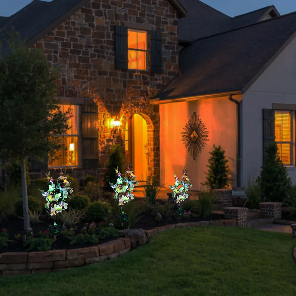 Solar-powered cherry blossom string lights with ground spike for outdoor garden decoration.