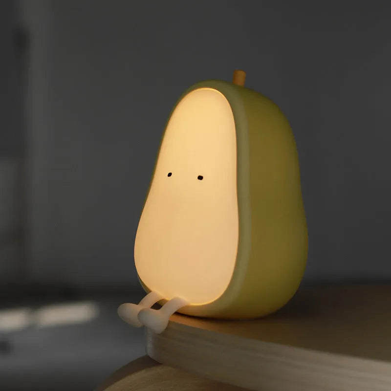 Yellow silicone pear-shaped rechargeable LED night light on a surface