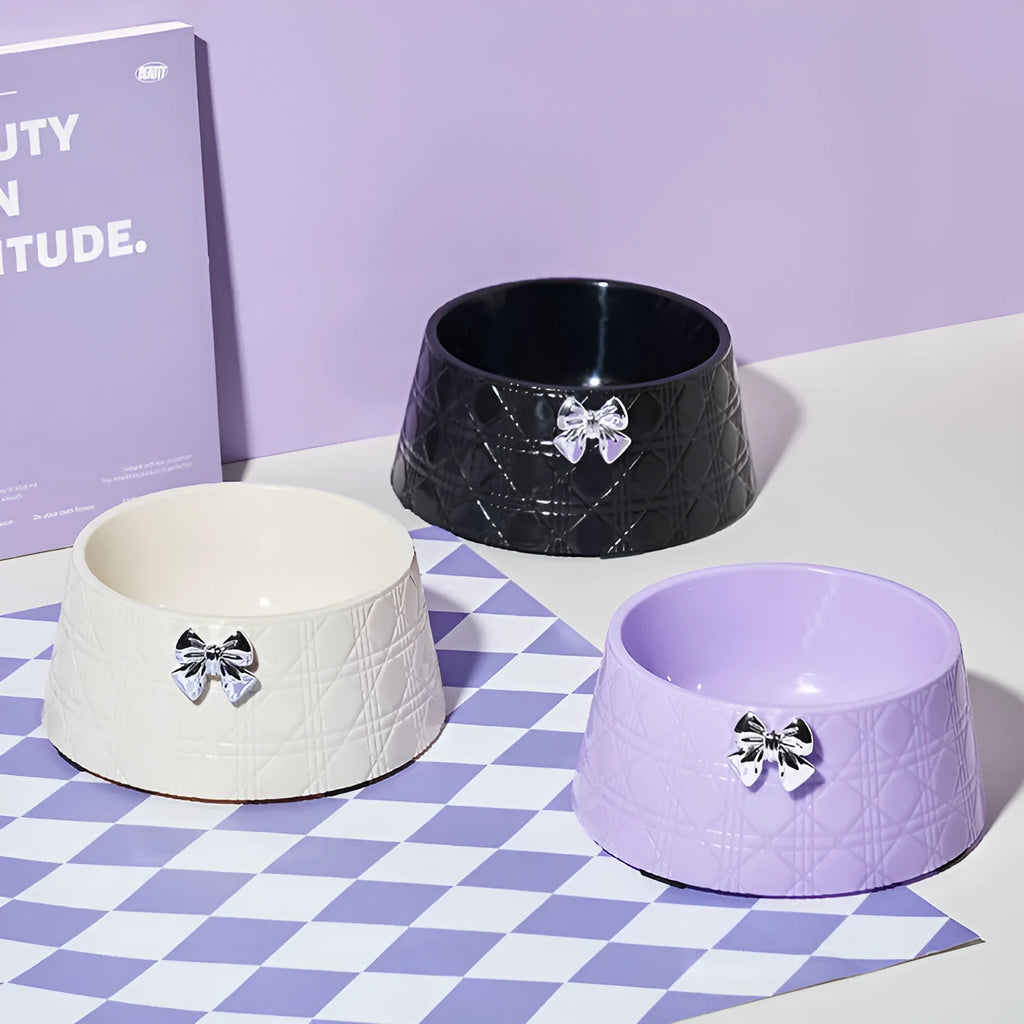 Decorative pet bowl with bowknot and diamond pattern in pink, silver, black, purple, and white colours.