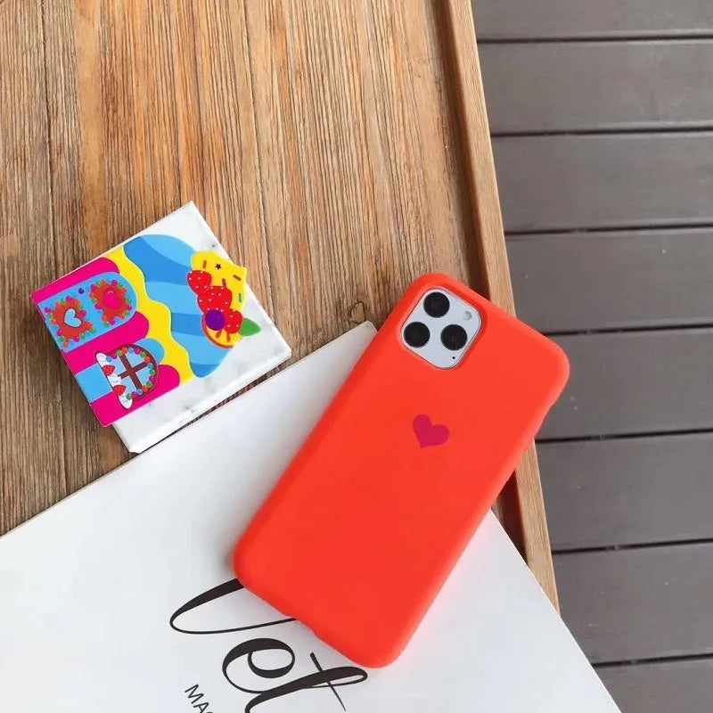 Simple solid-colour silicone phone case for iPhone, shown in a selection of colours including dark green and light pink.
