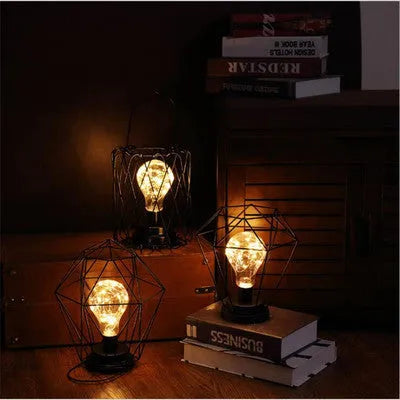 Minimalist hollow iron table lamp in a red wine bottle style with warm white LED light.
