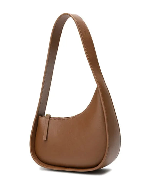 Leather ladies handbag in half-moon shape with wide shoulder strap and zipper opening