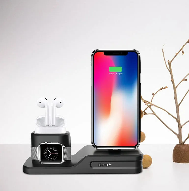 Black silicone 3-in-1 charging stand for iPhone, iWatch, and AirPods on a desk