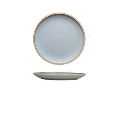 A 10-inch diameter pure blue matte ceramic dinner plate with a subtle textured finish on a wooden table.