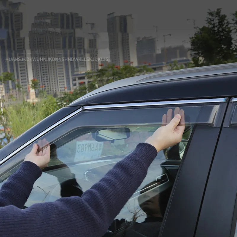 Black and translucent plastic window deflectors installed on a grey Mitsubishi Outlander SUV.