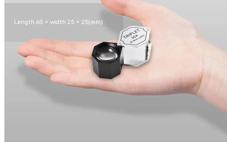Handheld metal and optical glass magnifying loupe for jewellery and coin inspection.