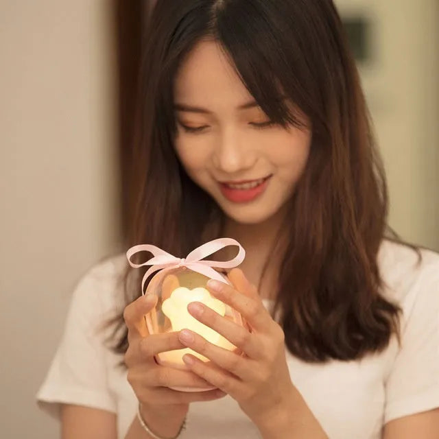 Grey cat paw shaped night light with USB charging port and control button showing soft illumination