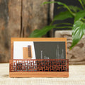 Geometric bamboo business card holder on a desk, showing natural wood grain and card slots.