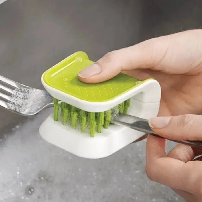 Blue U-shaped plastic brush for cleaning kitchen knives and cutlery on a kitchen counter.