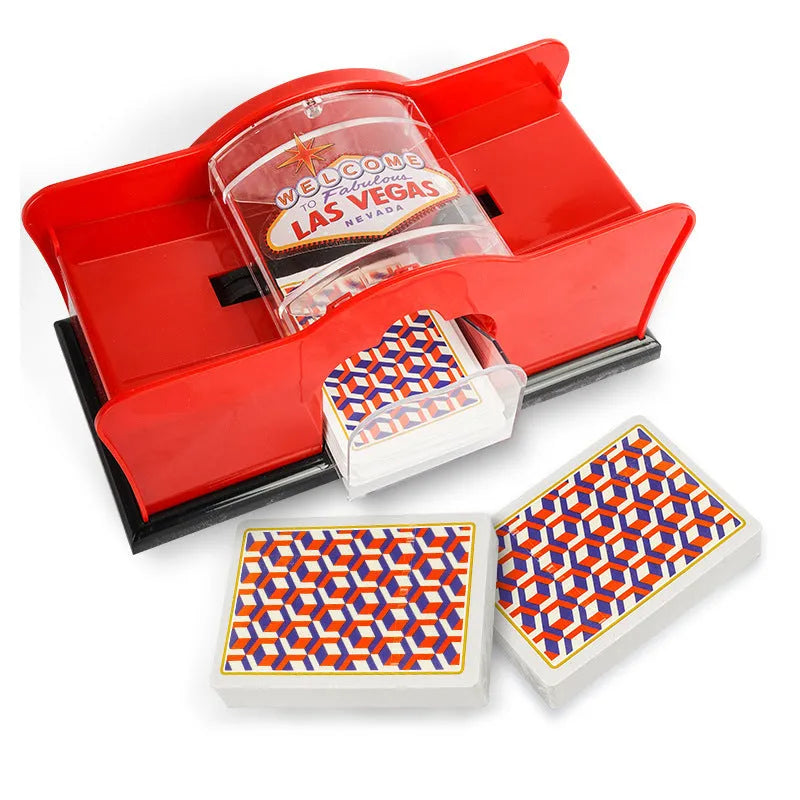 Black manual card shuffler with hand crank on a table next to playing cards.