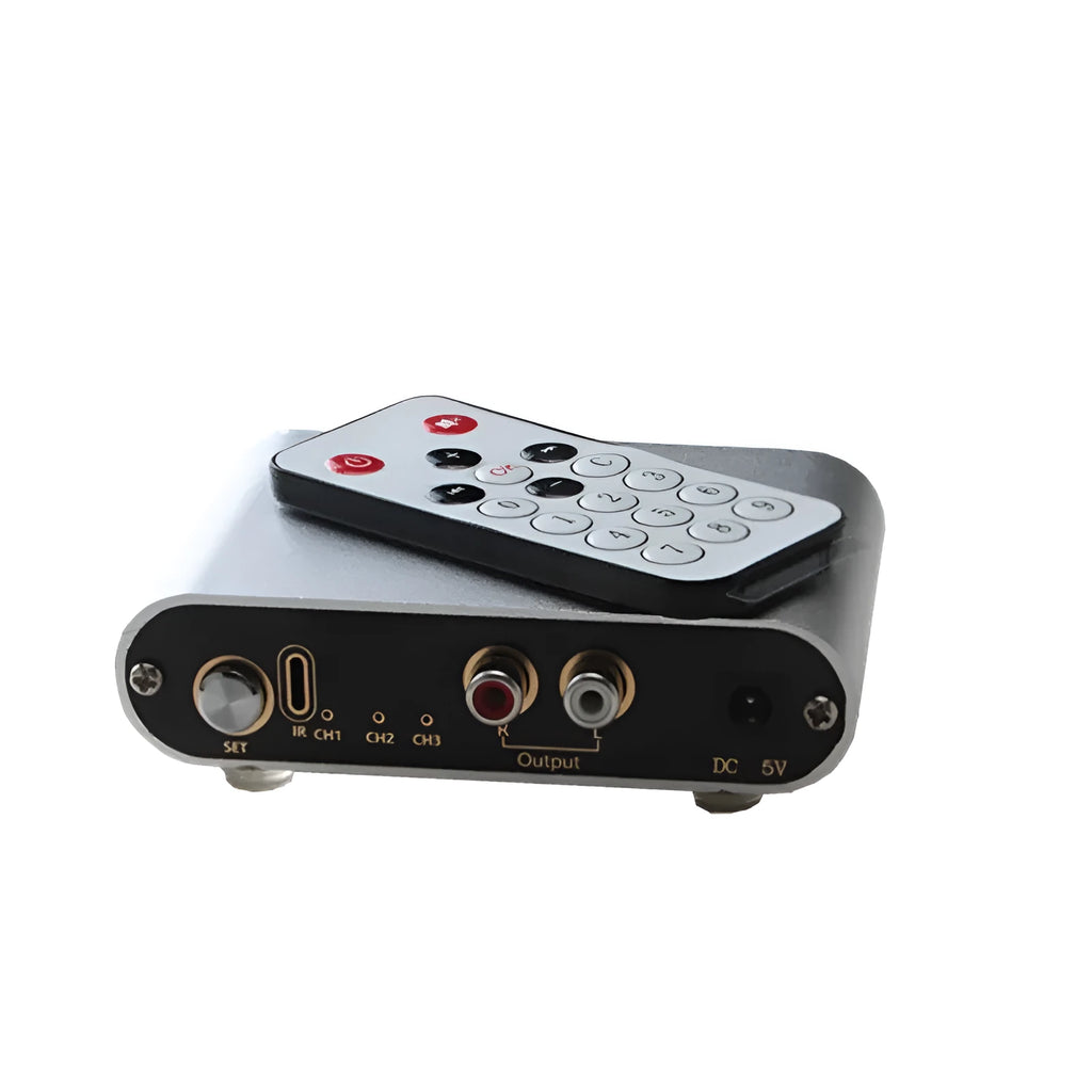 Silver aluminium alloy audio source switcher unit with front-panel switch button and infrared remote control.