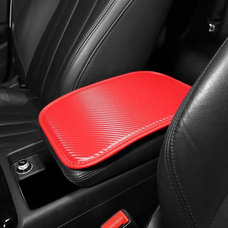 Leather car armrest cushion in black, khaki, red, and white colours, shown on a car centre console.