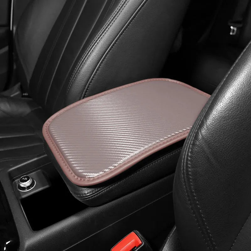 Leather car armrest cushion in black, khaki, red, and white colours, shown on a car centre console.