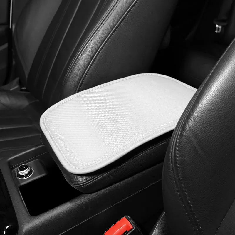 Leather car armrest cushion in black, khaki, red, and white colours, shown on a car centre console.