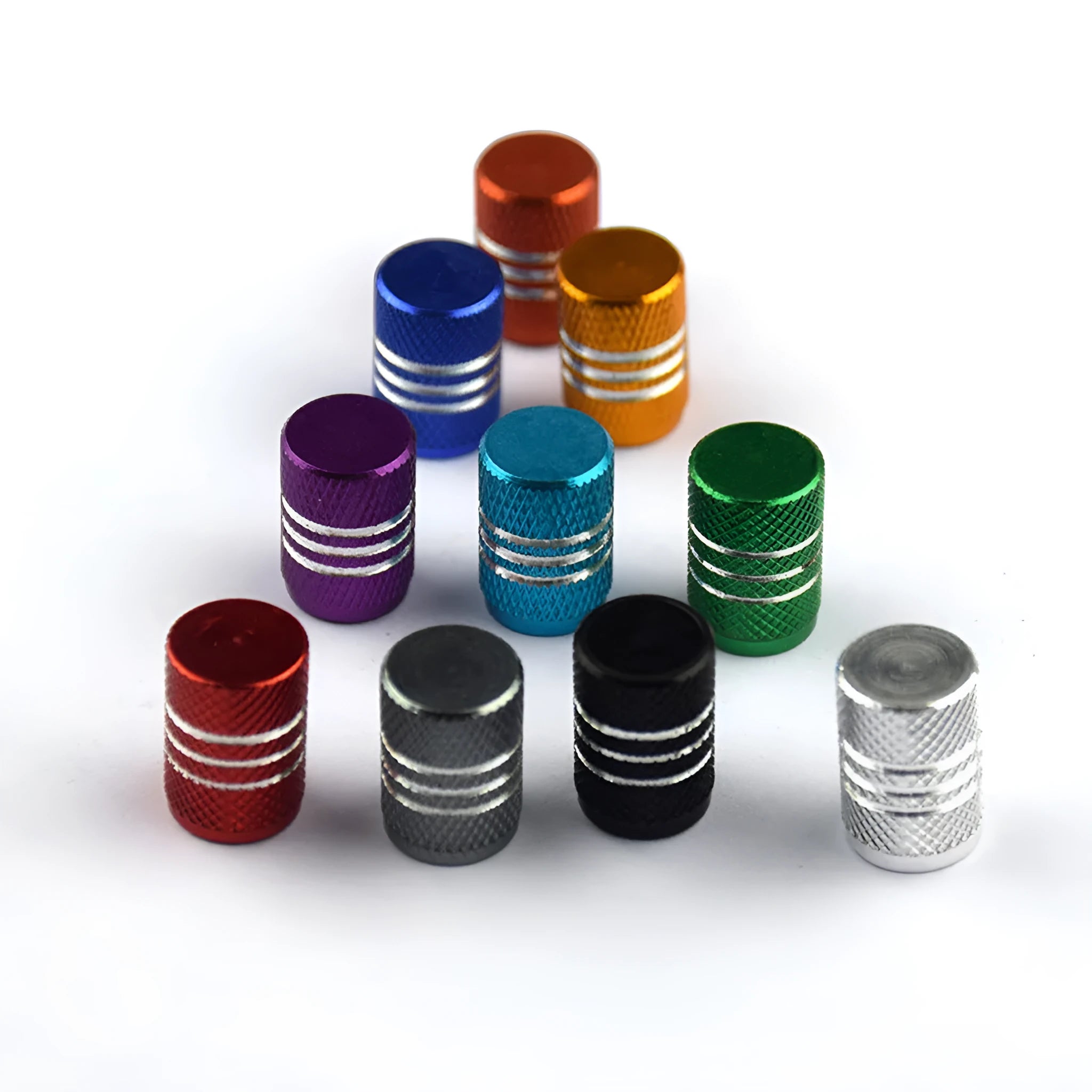 Set of coloured aluminium alloy car tyre valve caps with stainless steel cores on a grey background.