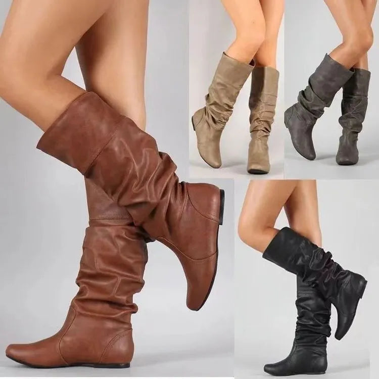 Women's flat heel slip-on boots in black with round toe and high cylinder length, showcasing non-slip rubber sole.