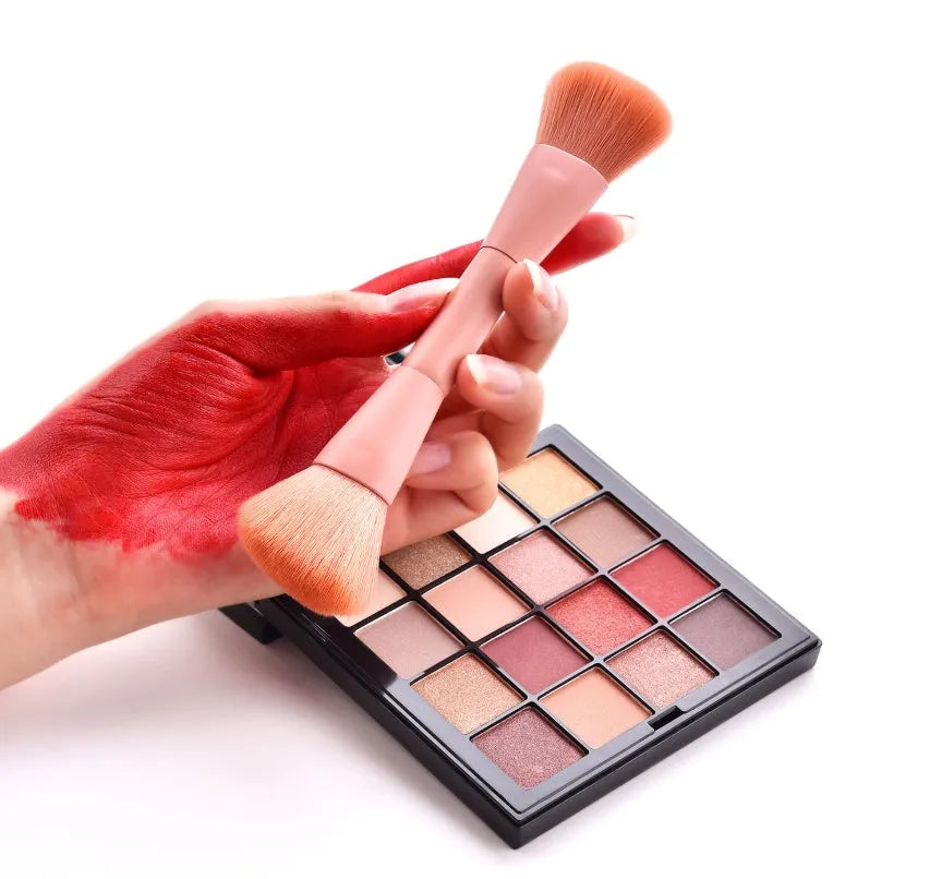 10 cosmetic brushes with wooden handles and nylon bristles arranged with makeup products