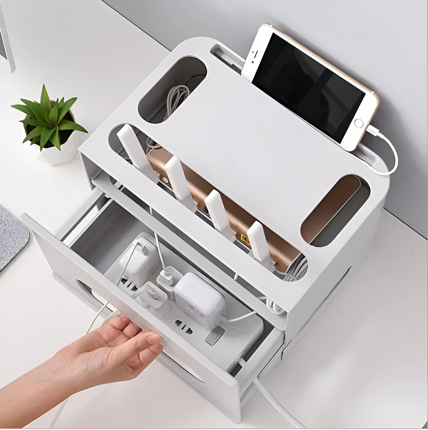White plastic wireless router storage box mounted on a wall with cables routed through internal channels.