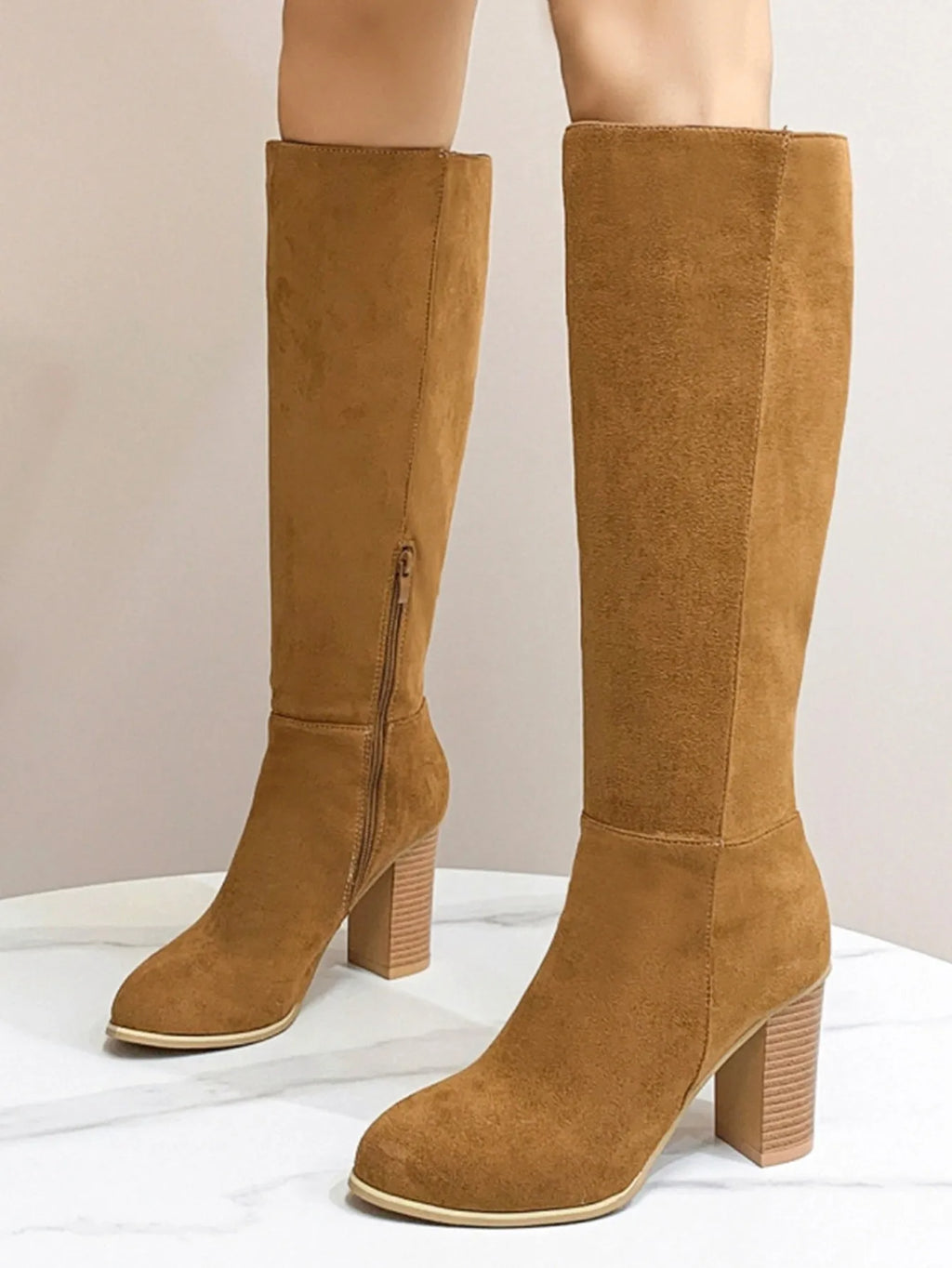 Women's black square toe ankle boots with a block heel on a wooden floor.