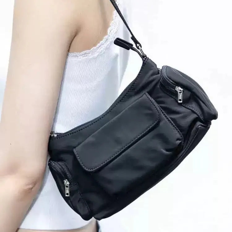 Black shoulder bag with two pockets showing side line detailing, measuring 24cm long by 9cm wide