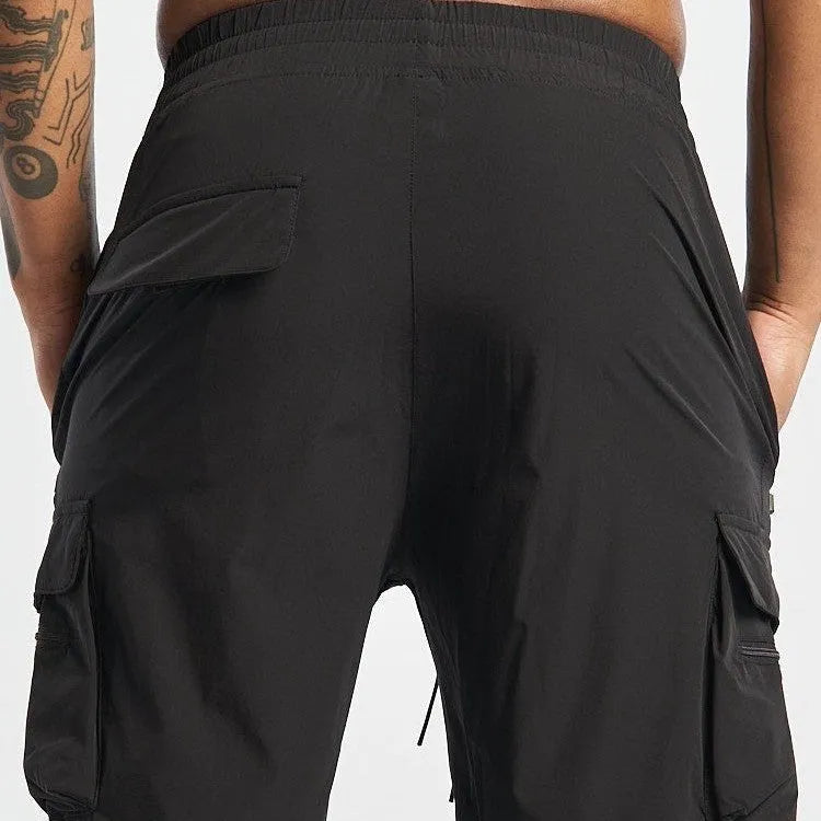 Men's black quick-dry sports shorts with four-sided stretch, shown on a model for running and fitness.