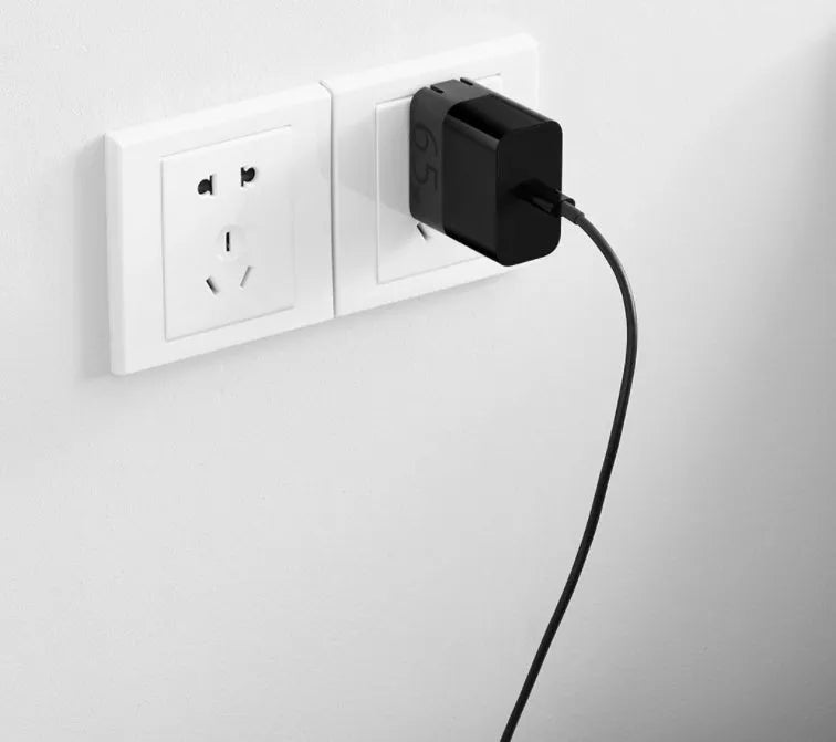 Black ZMI 65W USB-C laptop power adapter showing compact dimensions