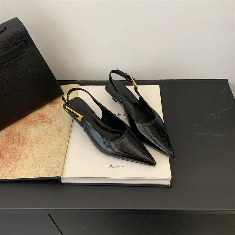 Women's black leather pointed toe shoes with a thin ankle strap and a low block heel.