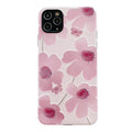 Pink soft rubber flower phone case for iPhone models on a flat surface, showing lanyard hole.