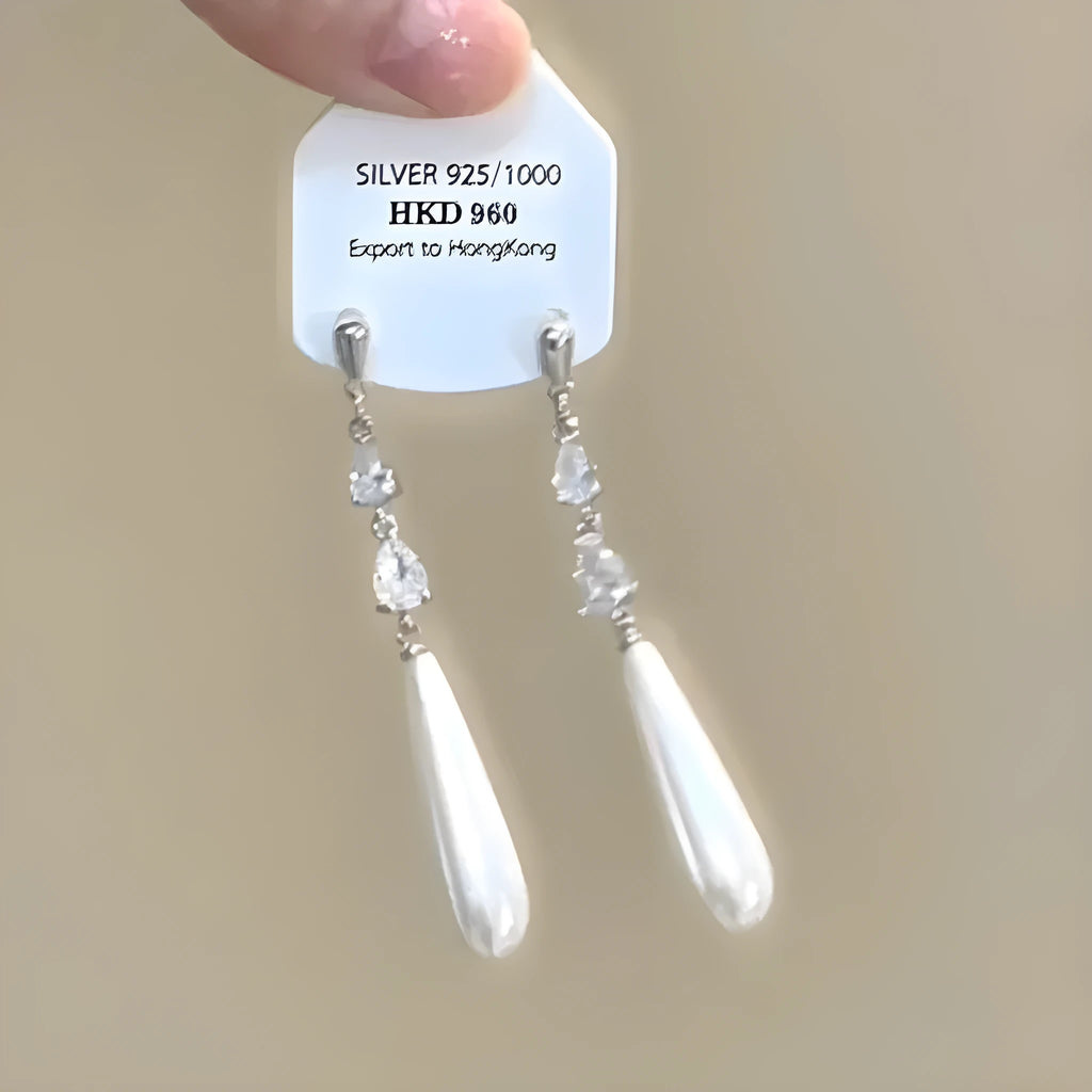 Geometric gold-tone clip-on earrings with a dangling tassel, rhinestone stars, and a heart charm.
