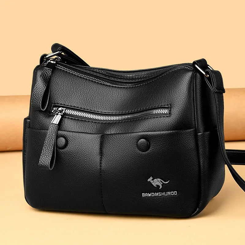 Women's soft leather crossbody bag in horizontal square shape with stitching details and crossbody strap