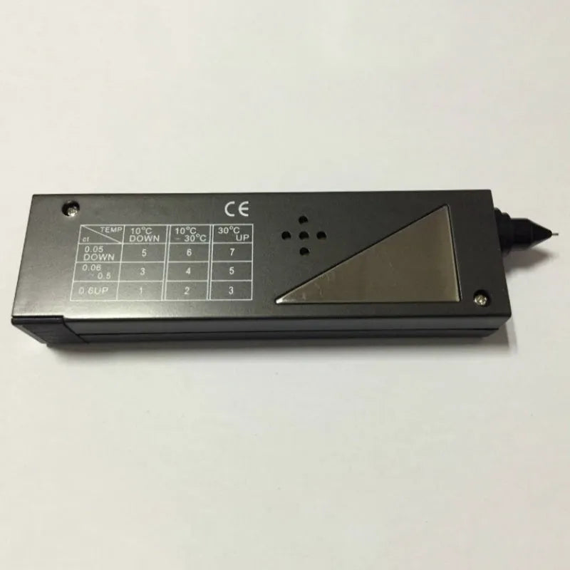 Black handheld diamond thermal conductivity tester with metal probe on a grey background.