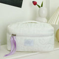 Silk quilted cosmetic bag in candy colours showing quilted pattern and storage capacity
