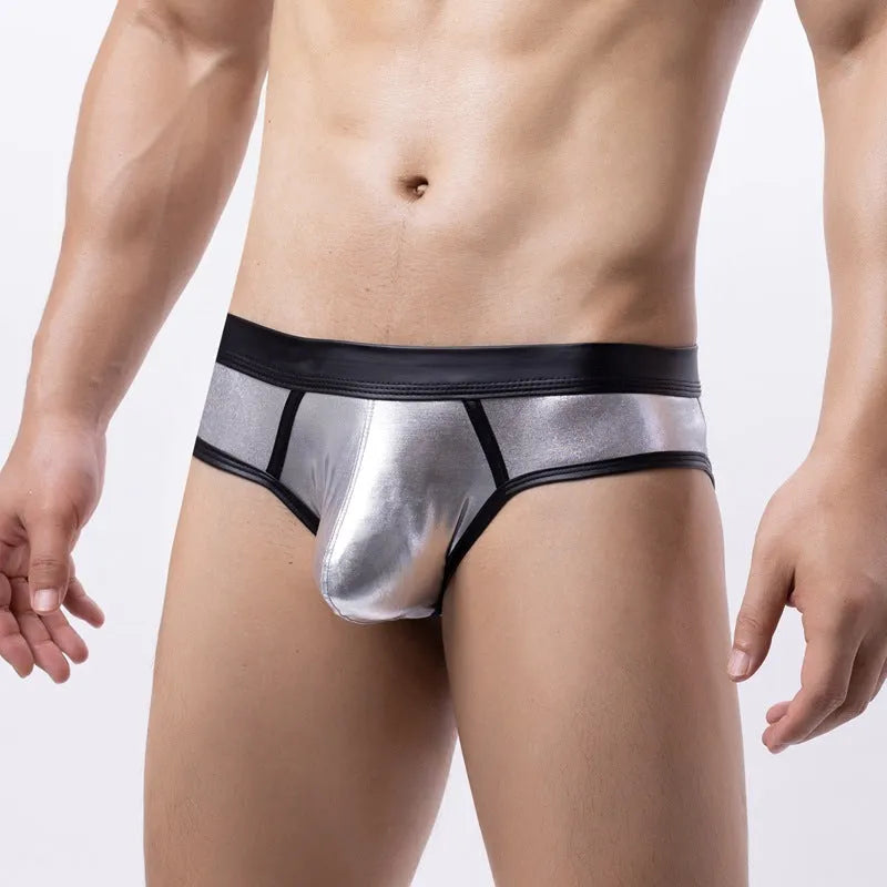 Man modelling gold patent leather look low-waist bikini swim briefs on beach