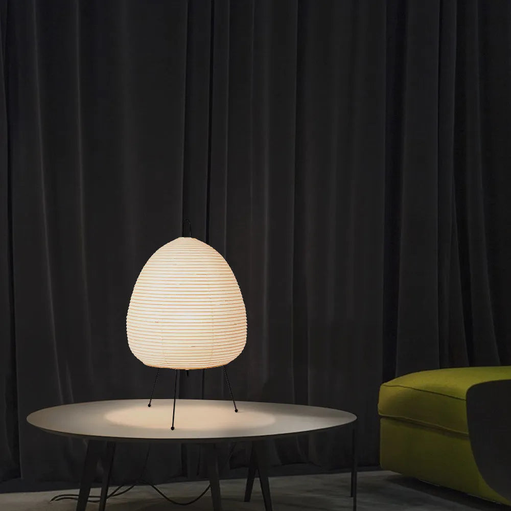 Japanese style rice paper table lamp with aluminium base on a wooden surface.
