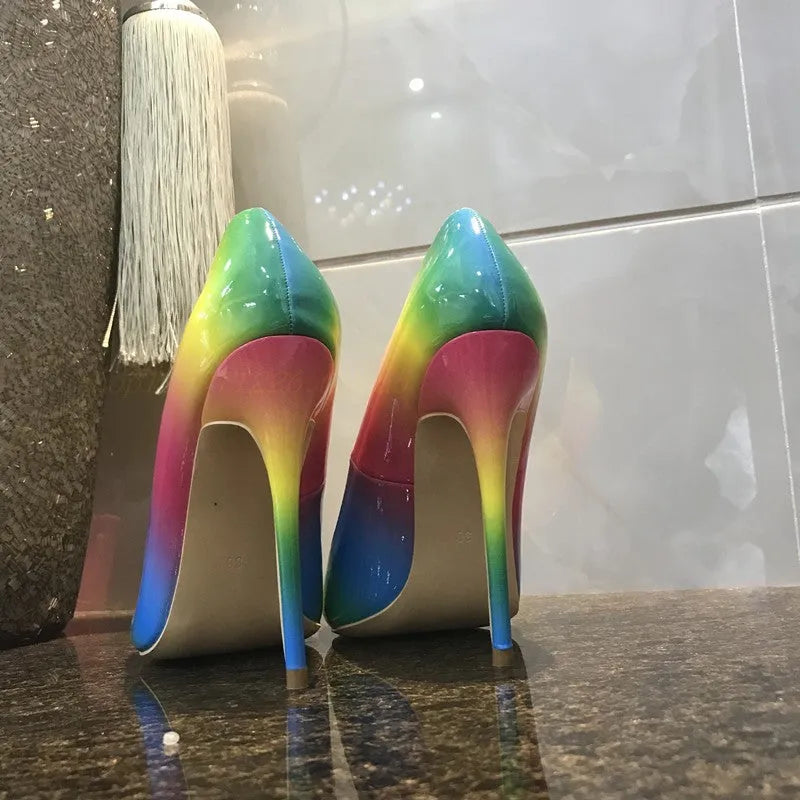Rainbow coloured patent leather women's high heel shoe with thin stiletto heel on a white background.