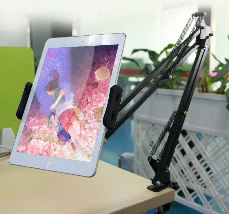 Black adjustable phone and tablet stand on a desk, measuring 10cm in height.